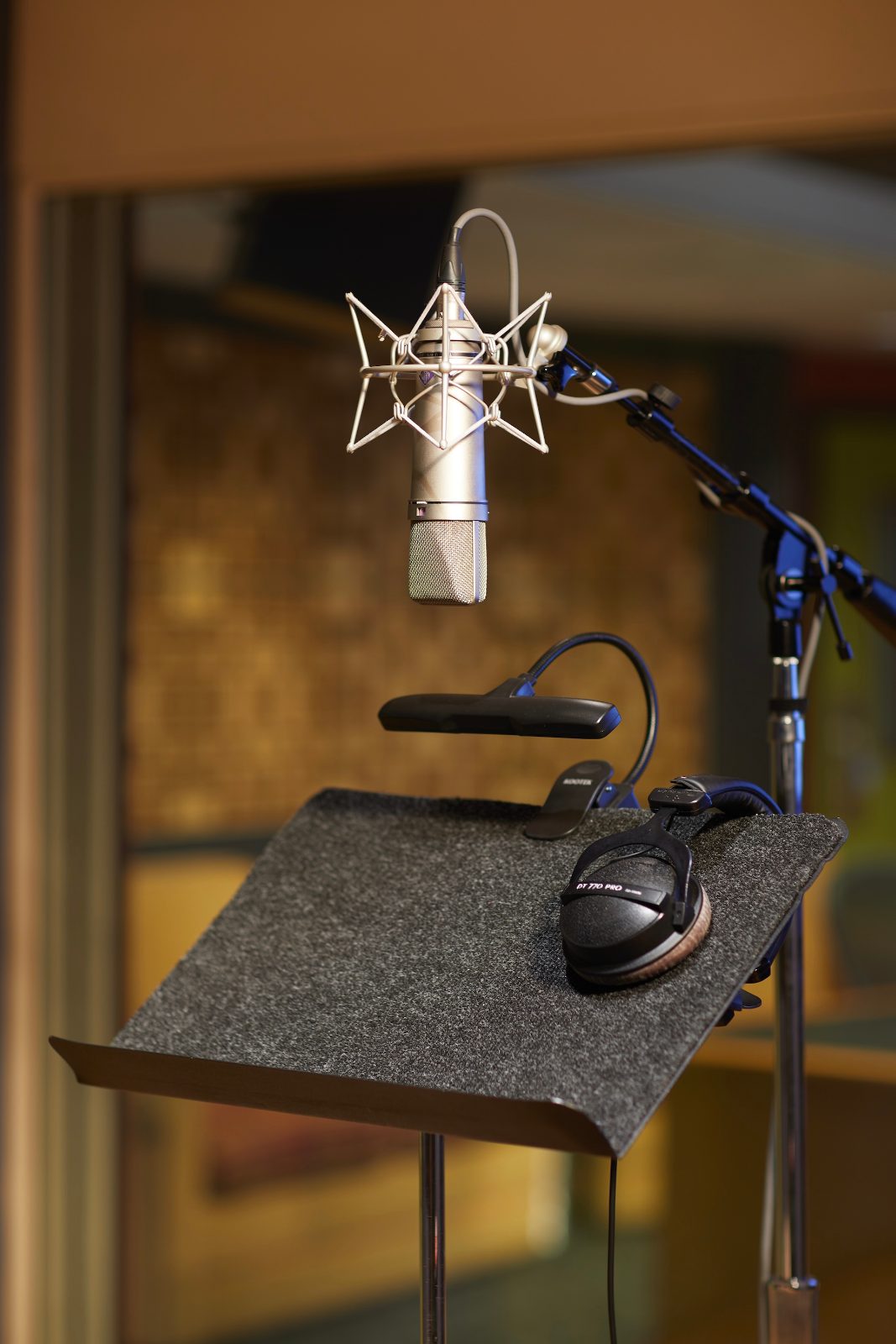 A Neumann U87 and headphones set up at a script stand