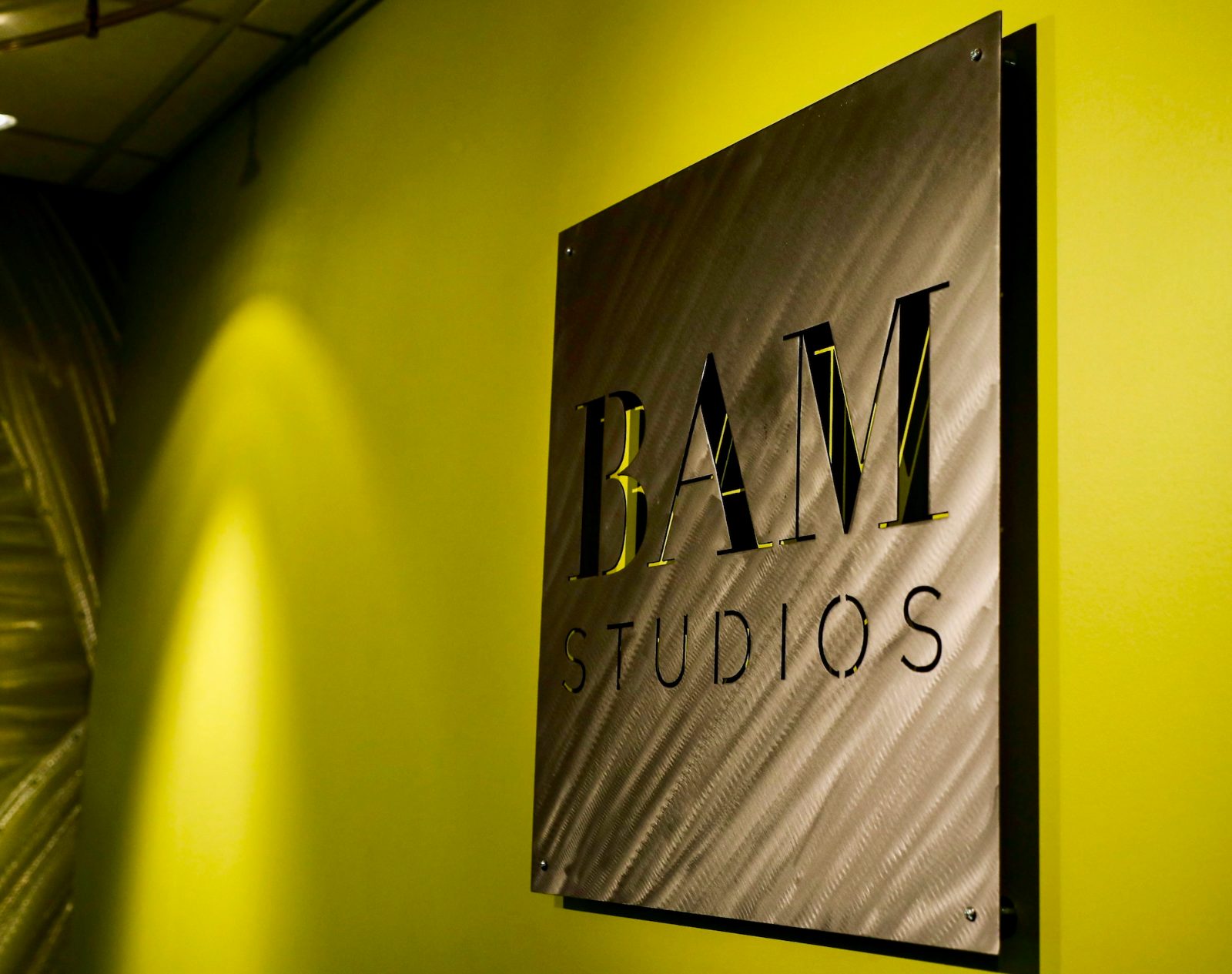 The brushed-steel BAM Studios sign in the lobby at BAM HQ
